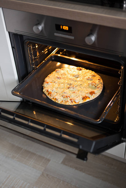 ízletes házi sajtos pizza forró sütőben - Fotó, kép
