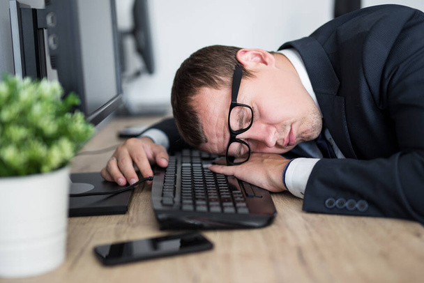 obchodní a stresový koncept - detailní portrét unaveného podnikatele spícího na stole v moderní kanceláři - Fotografie, Obrázek