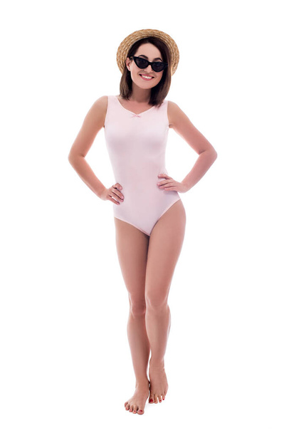 full length portrait of young beautiful woman in pink swimsuit and straw hat isolated on white background - Foto, imagen