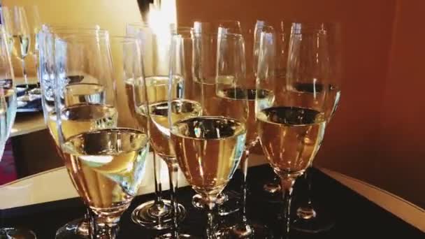 Kutlama etkinliği, lüks düğün ve büyük açılışta altın bayram ışığında şampanya ve beyaz köpüklü şarap. - Video, Çekim