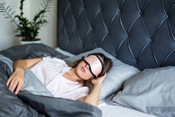 good morning concept - πορτρέτο της όμορφης γυναίκας που κοιμάται στο κρεβάτι με μάσκα στα μάτια - Φωτογραφία, εικόνα