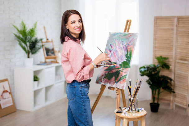 art, creativity and inspiration concept - beautiful woman artist painting at home or studio - Fotoğraf, Görsel