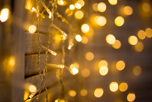 Kerst en nieuwjaar decoratie achtergrond - close-up van slinger lichten met bokeh effect - Foto, afbeelding