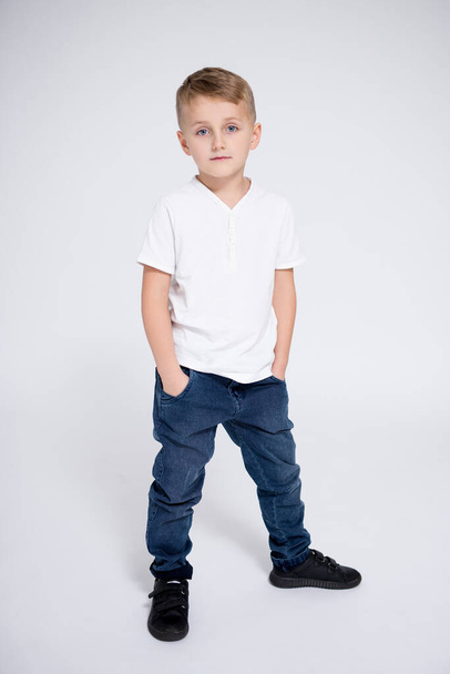 täyspitkä muotokuva söpö pieni poika poseeraa valkoisella taustalla - Valokuva, kuva