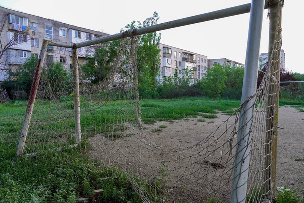 campo di calcio abbandonato, gol con una rete strappata in un terreno abbandonato - Foto, immagini
