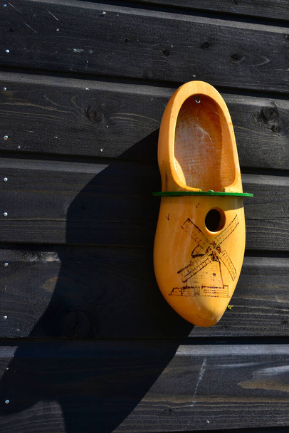 Старая окрашенная в желтый цвет деревянная обувь в качестве гнездовой коробки на сарае, Нидерланды
. - Фото, изображение