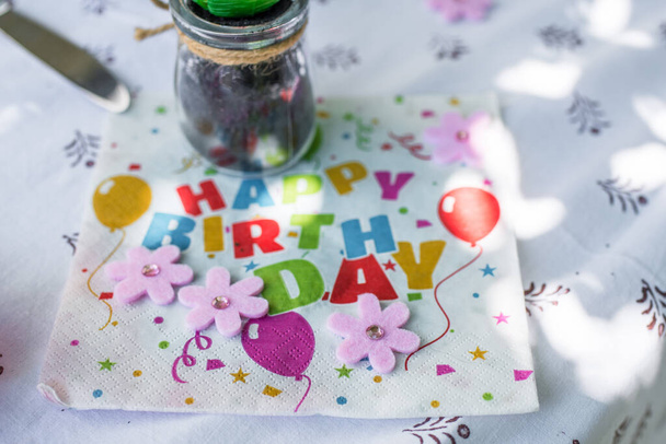 Tovagliolo di carta su un tavolo con le parole - Buon compleanno - in inglese con posate per tovaglie e decorazioni per la tavola, Germania - Foto, immagini