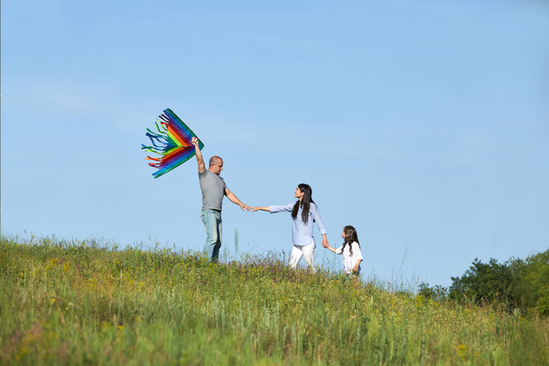 happy family with child girl launches kites - Foto, Bild
