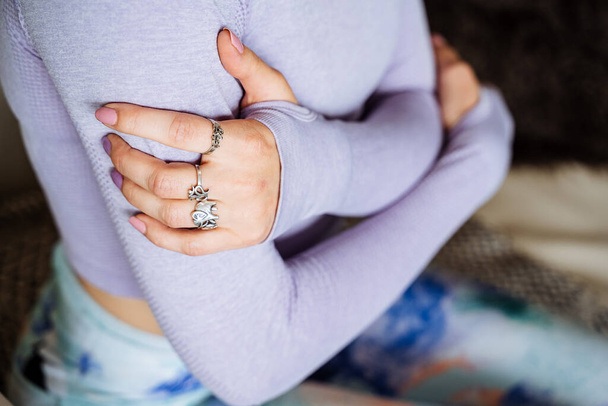 bílá dívka v šeříkovém saku si položí ruce kolem ramen, prsteny na prstech - Fotografie, Obrázek