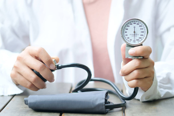 La doctora revisa el monitor de presión arterial y el indicador de presión del monitor de frecuencia cardíaca. Salud y concepto médico
 - Foto, imagen