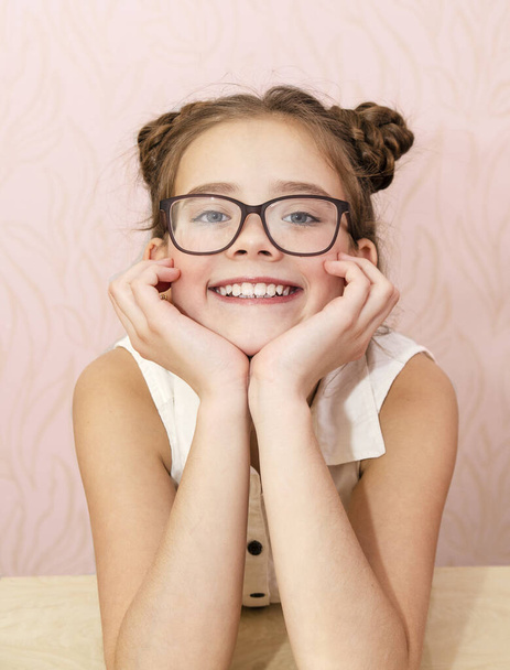 Cute little girl child preteen in eyeglasses education, school and vision concept isolated on a pink - Фото, зображення