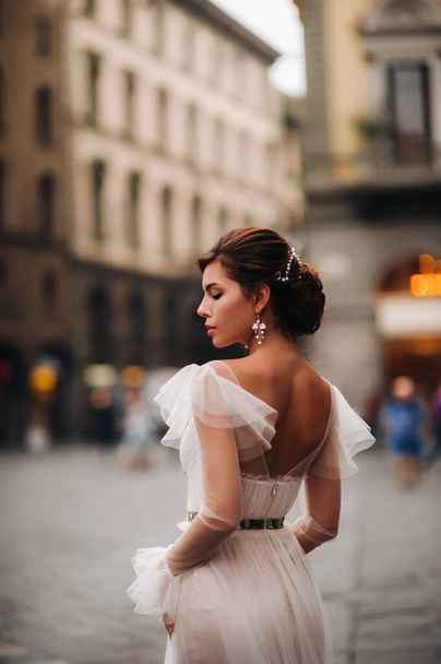 girl-bride wedding dress with a beautiful floral pattern in Florence, stylish bride in a wedding dress stands in the Old city of Italy. Model girl in Florence. - Фото, зображення