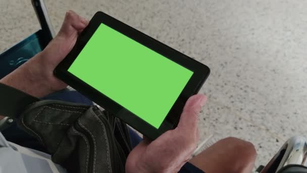 4K záběry v reálném čase close-up ruku invalidní asijské starý muž drží digitální tablet s chroma klíč zelené obrazovce pozadí sedí na invalidním vozíku  - Záběry, video