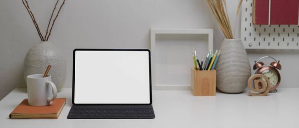 Nahaufnahme einer Tablet-Attrappe mit drahtloser Tastatur auf einem modernen Home-Office-Schreibtisch mit Kopierraum, Zubehör und Dekorationen - Foto, Bild