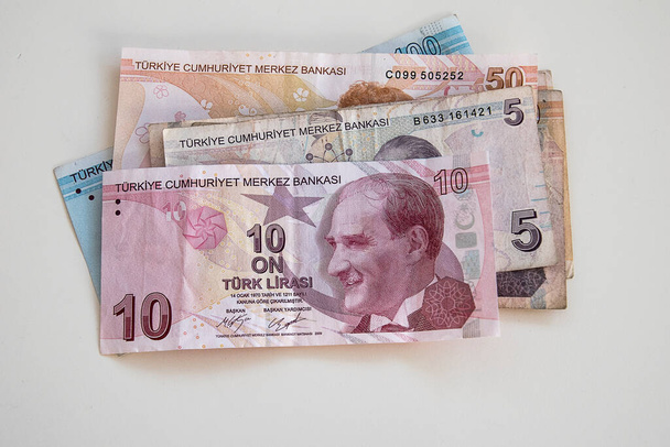 several Turkish paper banknotes lying on a white table - Fotó, kép