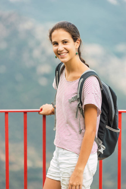 Девушка-путешественница в объективе камеры в красивом месте с горами на заднем плане
 - Фото, изображение