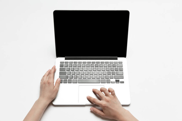 Close up of human hand using laptop with blank black screen, education and business concept - Foto, Imagem