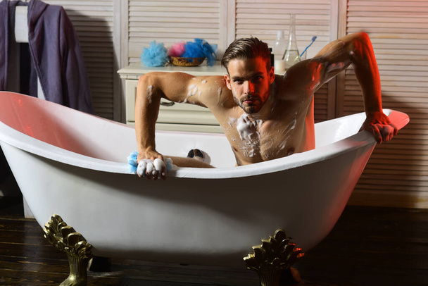 Guy with beard and seductive face in bathtub - Фото, изображение