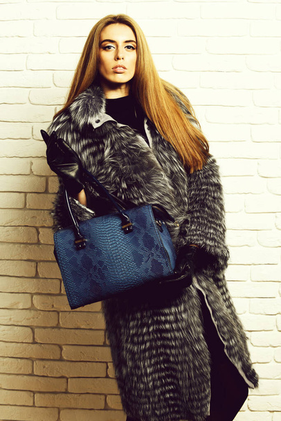 fashionable sexy woman in fur on brick wall studio background - Фото, изображение