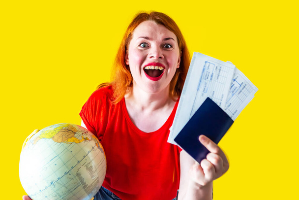 Portrét krásné zrzky dívka s glóbus a dokumenty na žlutém pozadí, cestovní koncept - Fotografie, Obrázek
