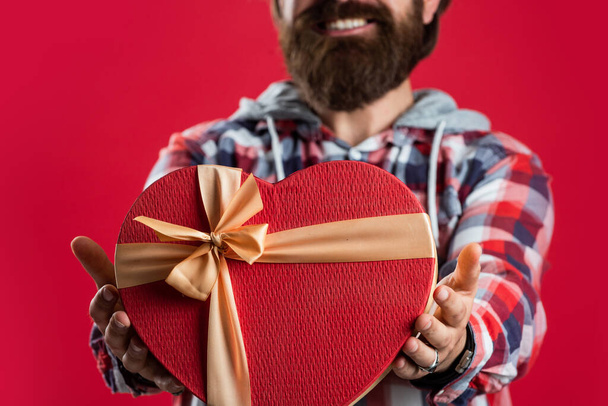 birthday surprise for her. anniversary of marriage. happy valentines day. heart is symbol of love. bearded man casual style hold gift box. time for presents. love holiday and vacation. Be happy - Φωτογραφία, εικόνα