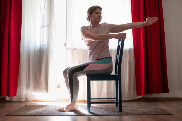 Žena cvičení na jógu nebo pilates cvičení pomocí židle. - Fotografie, Obrázek
