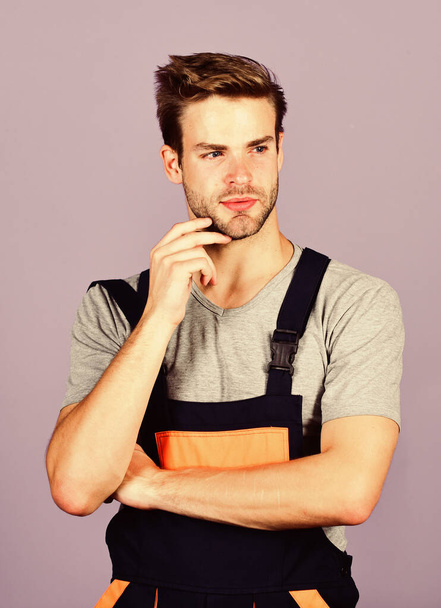 Assemble and set up machinery or equipment. Thoughtful repairman. Handsome repairman. Worker violet background. Man repairman builder in work clothes. Troubleshoot and fix faulty electrical switches - Фото, зображення