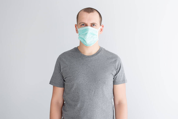 koronaviruksen suojaus ja karanteeni - mies lääketieteellisessä naamiossa valkoisella taustalla - Valokuva, kuva