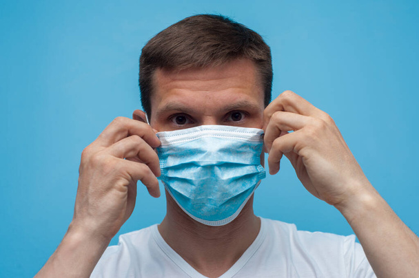Portrait of man wearing an anti virus protection mask to prevent corona virus. - Фото, изображение