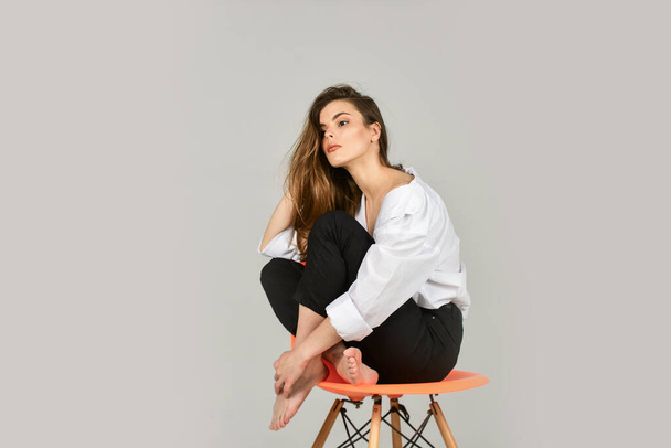 Young perfectionist. hairdresser beauty salon. elegant fashion model. girl wear office shirt and pants. her casual style. stylish business woman. sexy woman relax on chair. female beauty and fashion - Foto, imagen