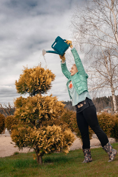 woman gardener with watering can in the garden  - Fotó, kép