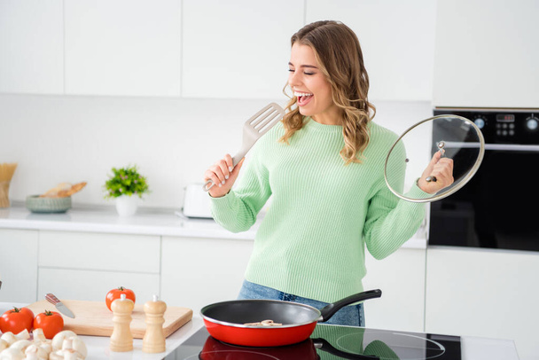 Portrait of her she nice attractive lovely funny cheerful cheery wavy-haired girl cooking homemade lunch singing having fun in modern light white kitchen indoors - Φωτογραφία, εικόνα