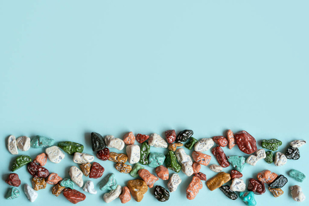 Colorful pebbles stones for decoration and for hand made works. Colorful stone, texture on the blue background. Concept we are all different. - Foto, immagini