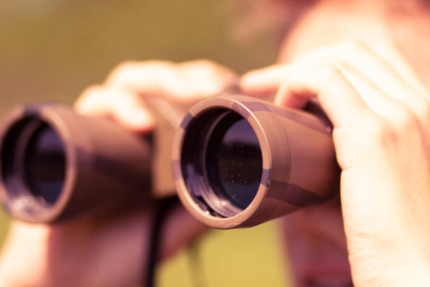A young man with military binoculars in his hands - Foto, imagen