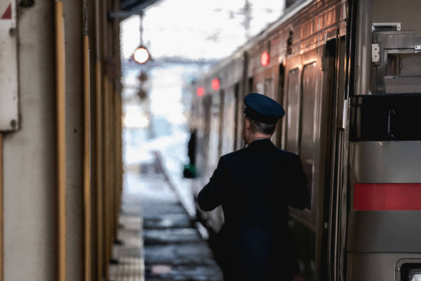 Железнодорожный инженер проверяет пассажиров, которые благополучно въезжают на платформу или нет
. - Фото, изображение