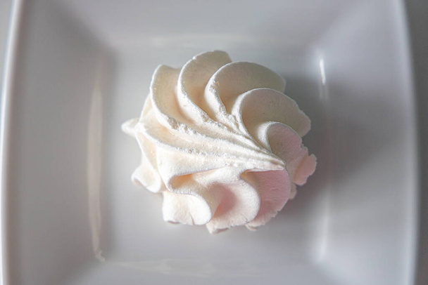 mały biały smaczny słodki bezy na białym talerzu - Zdjęcie, obraz