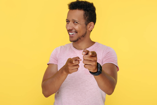 Delighted african american young man pointing fingers to camera over yellow background. - Foto, Imagem