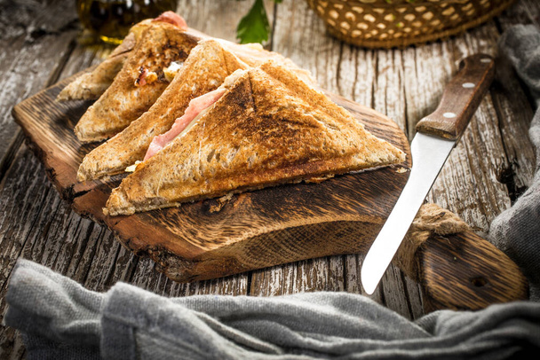 Grilled cheese sandwich on cutting board. Shallow depth of field. - Foto, immagini