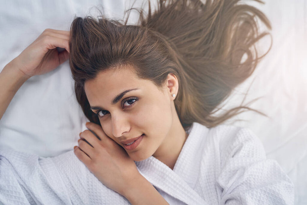 Attractive young woman resting on white sheets - Foto, immagini