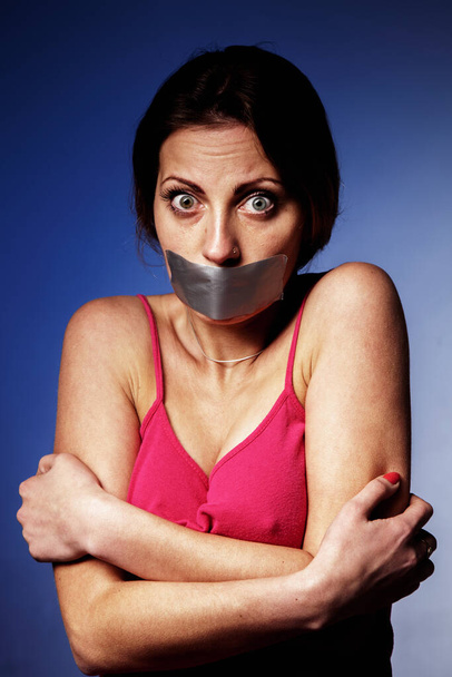 Pain, fear and censorship concept. Psychological portrait of scared woman with  mouth covered with a plaster.  - Photo, Image