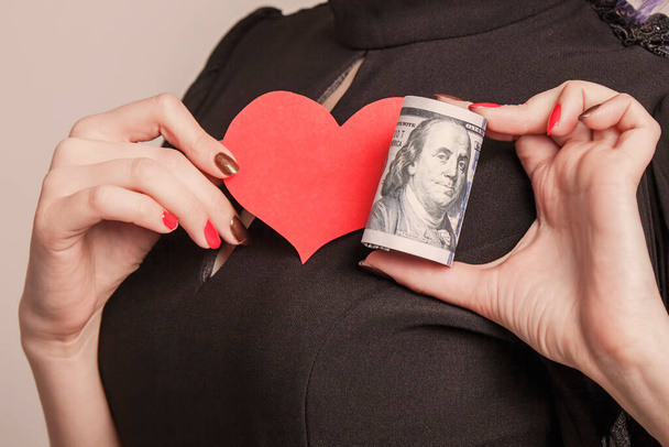Motivación, propósito, persistencia, amor y concepto de libertad. Mujer de negocios con corazón y dinero en efectivo como símbolo de amor por los dólares estadounidenses
.  - Foto, imagen
