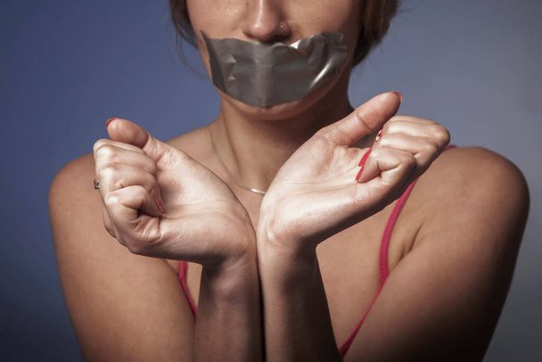 Retrato psicológico simbólico de mulher assustada com a boca coberta com um gesso. Falta de liberdade e independência
.  - Foto, Imagem