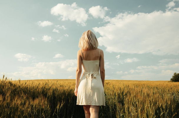 Красива блондинка в пшеничному полі під час заходу сонця
  - Фото, зображення
