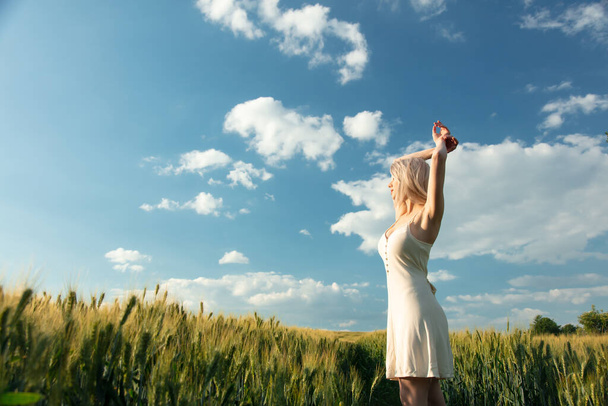 Krásná blondýnka dívka v pšeničném poli v západu slunce  - Fotografie, Obrázek