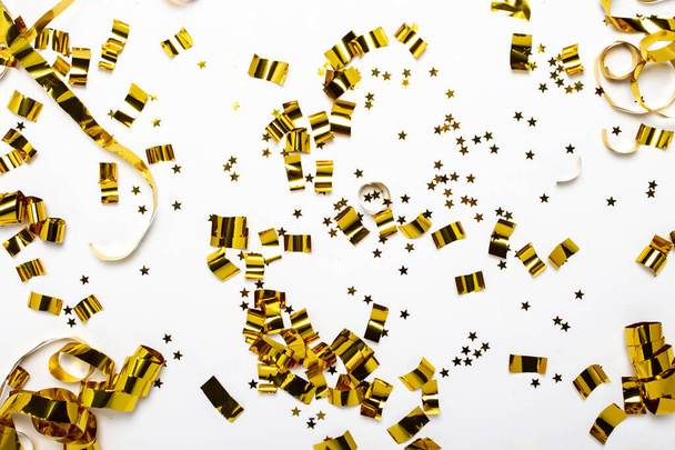 Golden confetti on a white background. The concept of a holiday, party, birthday, decoration. Banner Flat lay, top view. - Photo, Image