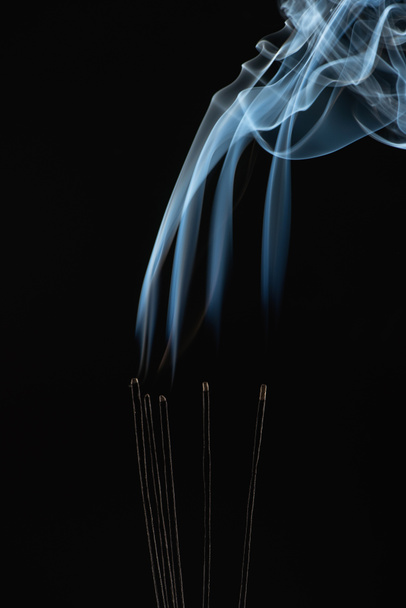 palos de aroma ardiente con humo sobre fondo negro
 - Foto, imagen