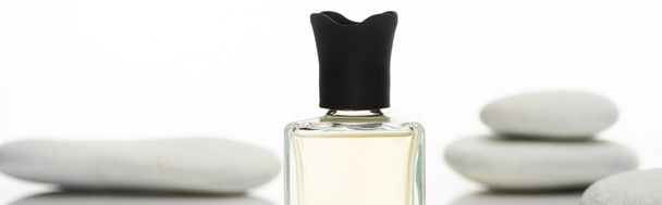 selektywne skupienie perfum domowych w butelce w pobliżu kamieni uzdrowiskowych odizolowanych na białym tle, panoramiczne ujęcie - Zdjęcie, obraz
