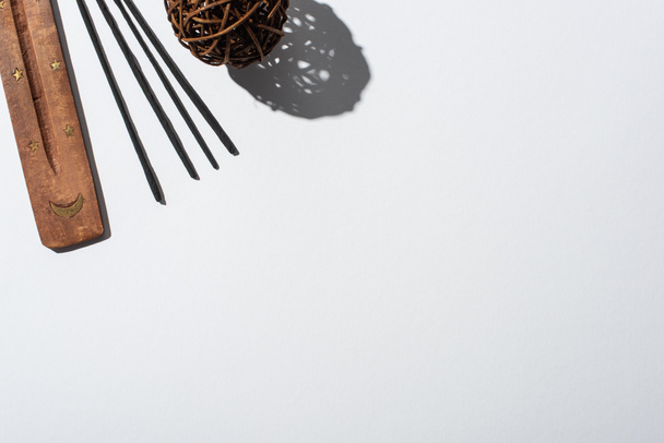 вид сверху на ароматные палочки, деревянный стенд и декоративный мяч на белом фоне
 - Фото, изображение