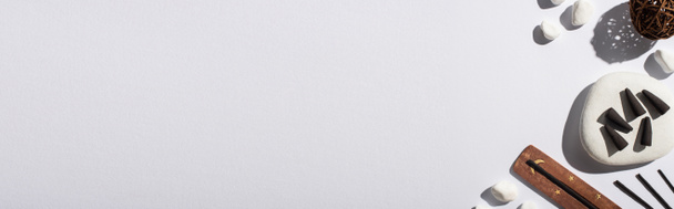 vista superior de conos de incienso negro, piedras, palos de aroma y bola decorativa sobre fondo blanco, tiro panorámico
 - Foto, imagen