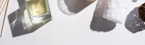 πάνω όψη των αρωματικών sticks με άρωμα σε μπουκάλι κοντά σε βαμβακερή πετσέτα σε λευκό φόντο, πανοραμική λήψη - Φωτογραφία, εικόνα